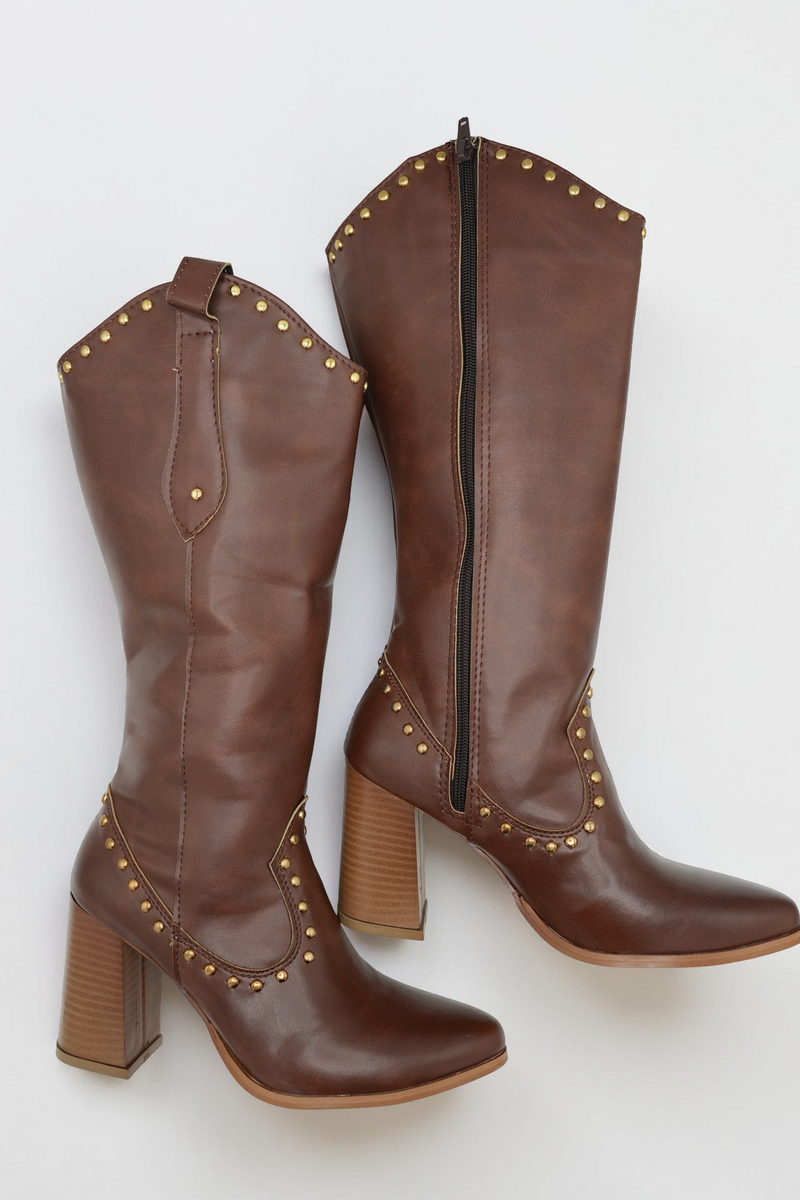 Pair of brown leather knee-high boots with studded details on a white background